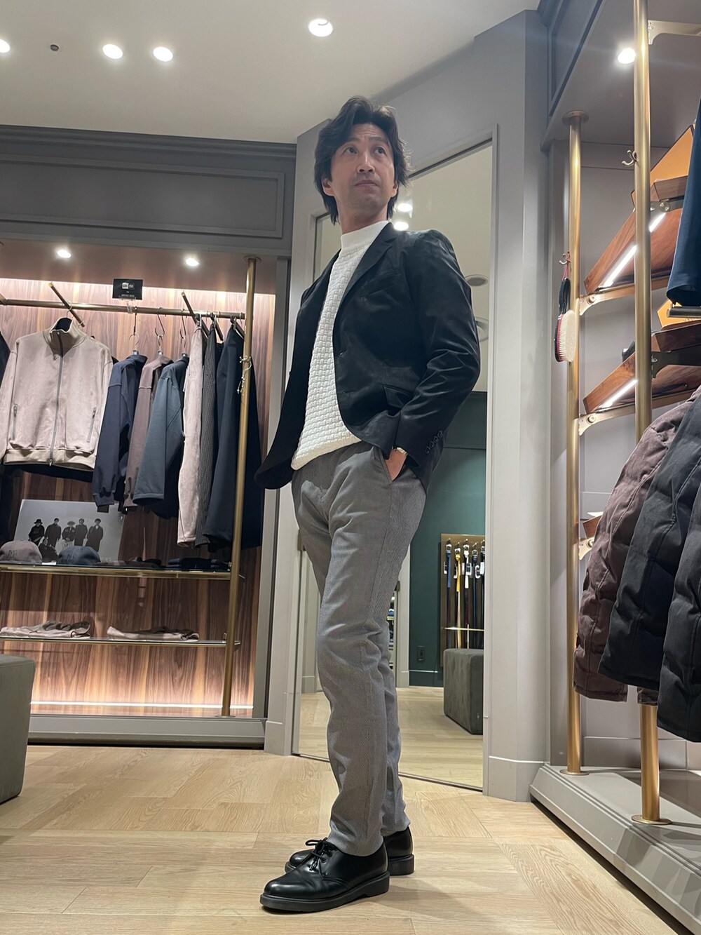 ブラック系のテーラードジャケット、グレー系のその他パンツ、ホワイト系のTシャツ/カットソーを着用したメンズの冬コーディネートの2枚目の写真