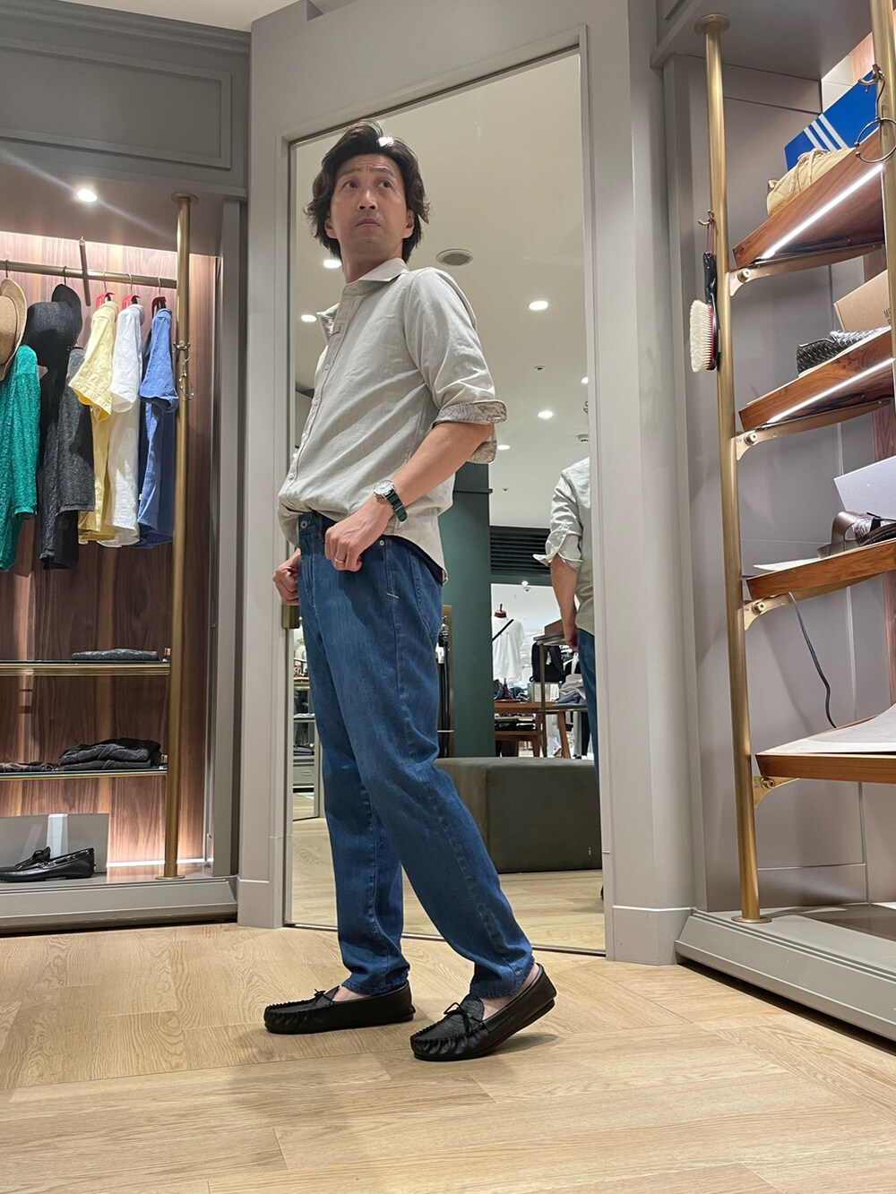 グレー系のシャツ/ブラウス、ブルー系のデニムパンツ、ブラック系のモカシン/デッキシューズを着用したメンズの夏コーディネートの3枚目の写真