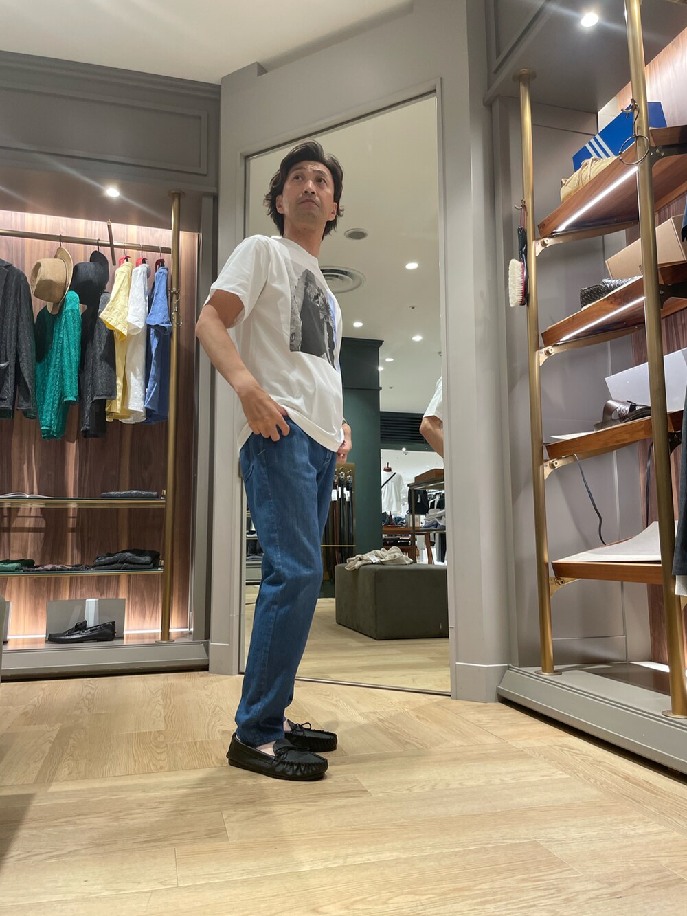 ホワイト系のTシャツ/カットソー、ブルー系のデニムパンツ、ブラック系のモカシン/デッキシューズを着用したメンズの夏コーディネートの4枚目の写真