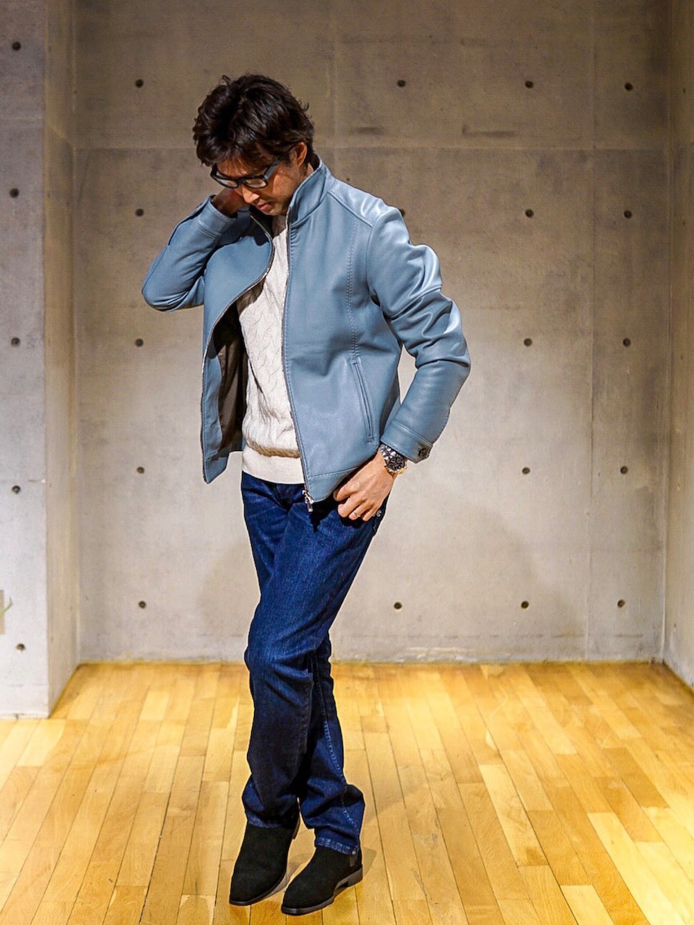ブルー系のデニムパンツ、ブルー系のライダースジャケット、ホワイト系のニット/セーターを着用したメンズの冬コーディネートの2枚目の写真