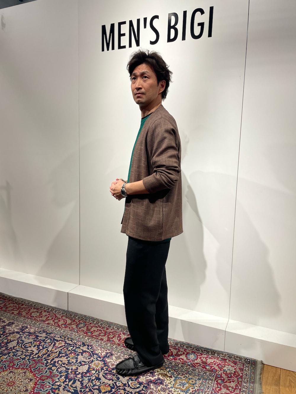 ブラック系のその他パンツ、ブラック系のモカシン/デッキシューズ、ブラウン系のカーディガン/ボレロを着用したメンズの春コーディネートの2枚目の写真