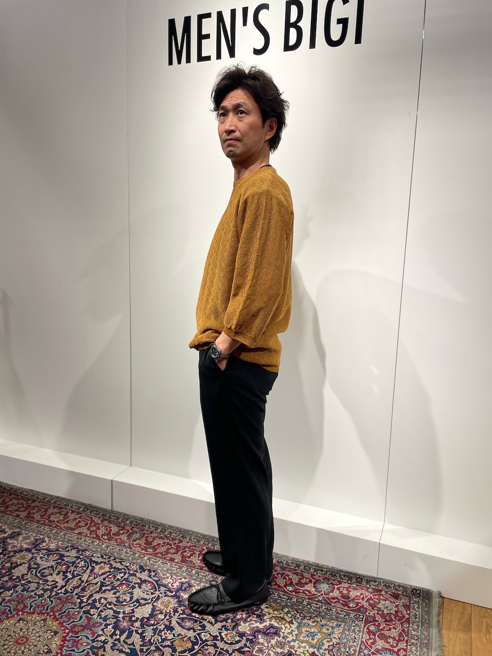 ブラック系のその他パンツ、イエロー系のニット/セーター、ブラック系のモカシン/デッキシューズを着用したメンズの春コーディネートの2枚目の写真
