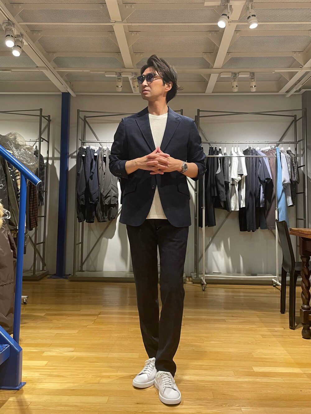 ブルー系のテーラードジャケット、ブルー系のスラックス、ホワイト系のスニーカーを着用したメンズの春コーディネートの2枚目の写真