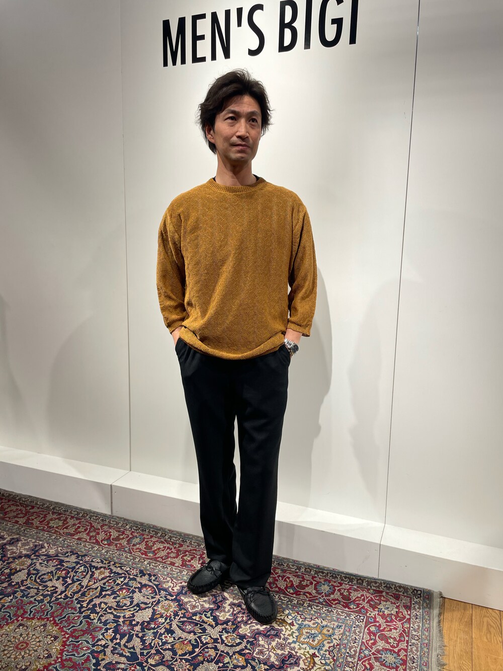 ブラック系のその他パンツ、イエロー系のニット/セーター、ブラック系のモカシン/デッキシューズを着用したメンズの春コーディネートの3枚目の写真