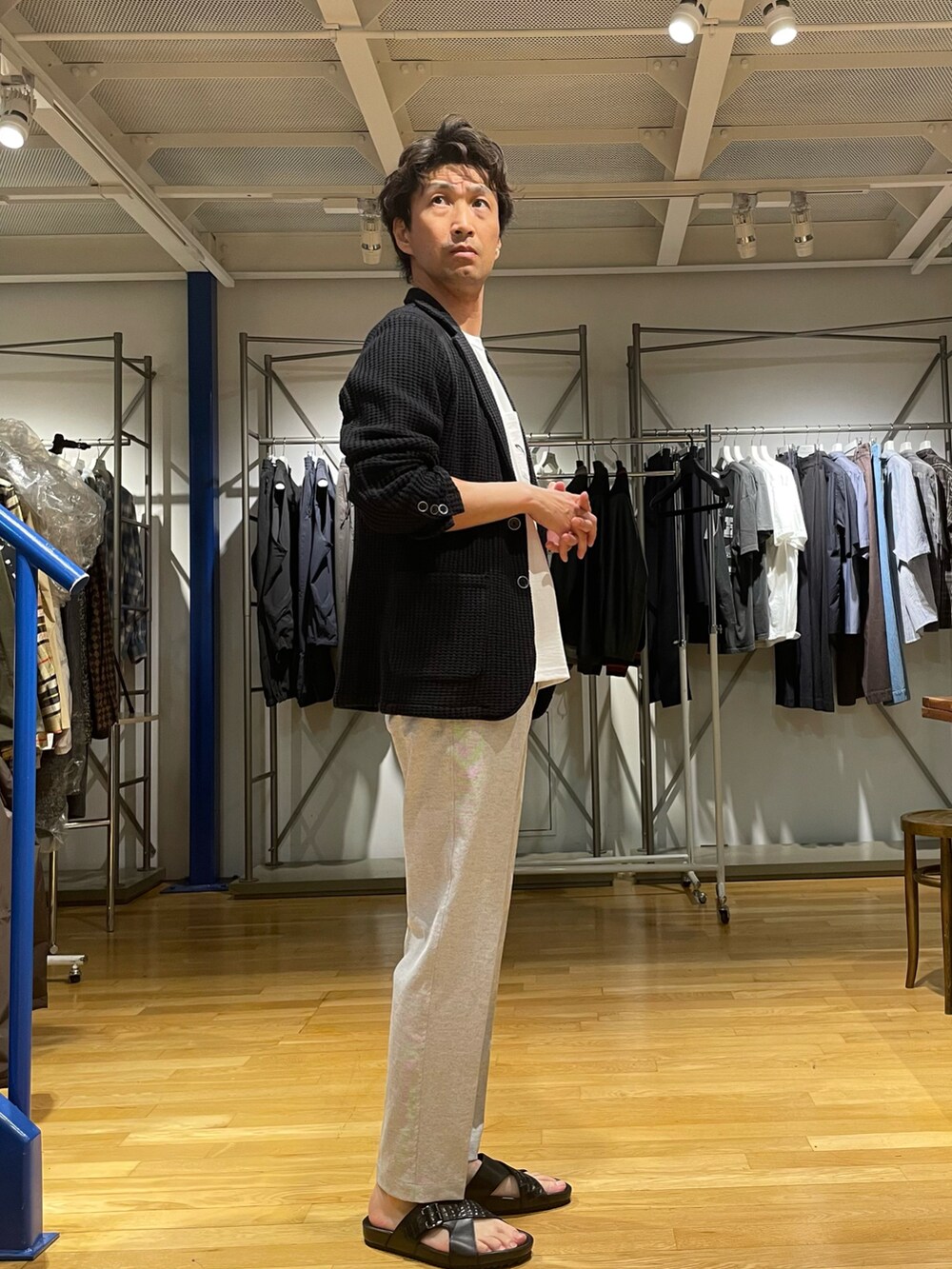 ブラック系のテーラードジャケット、ブルー系のその他パンツ、ブラック系のサンダルを着用したメンズの春コーディネートの2枚目の写真