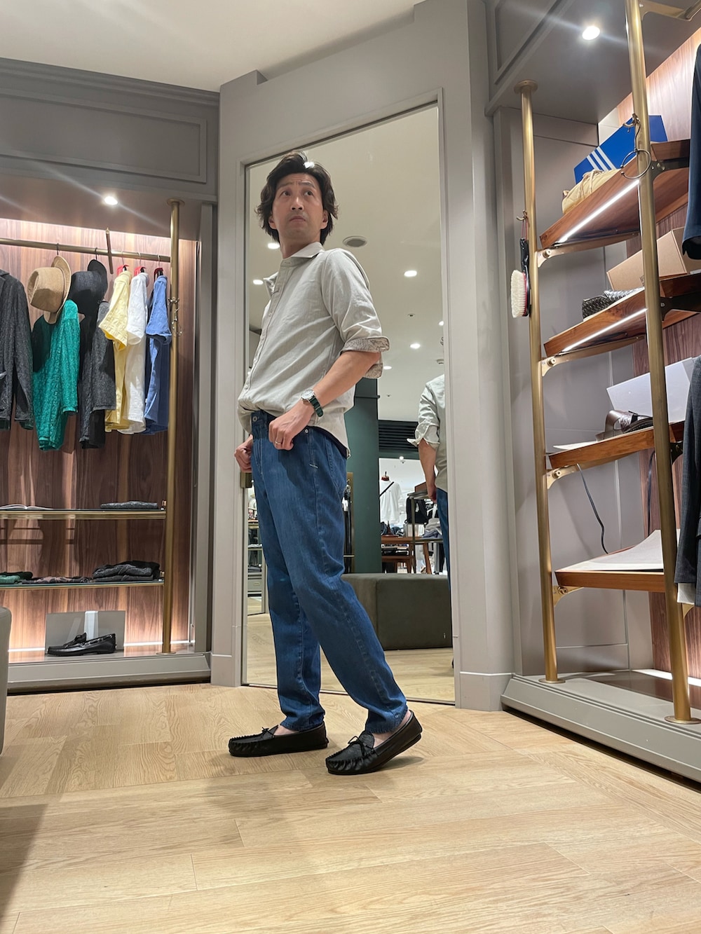 グレー系のシャツ/ブラウス、ブルー系のデニムパンツ、ブラック系のモカシン/デッキシューズを着用したメンズの夏コーディネートの3枚目の写真