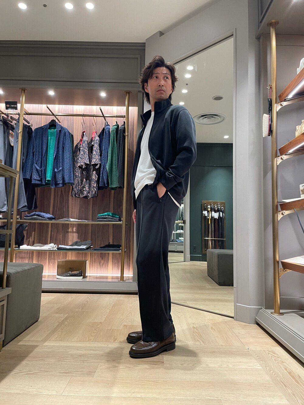ブラック系のその他アウター、ブラック系のスウェットパンツ、ブラウン系のドレスシューズを着用したメンズの春コーディネートの2枚目の写真