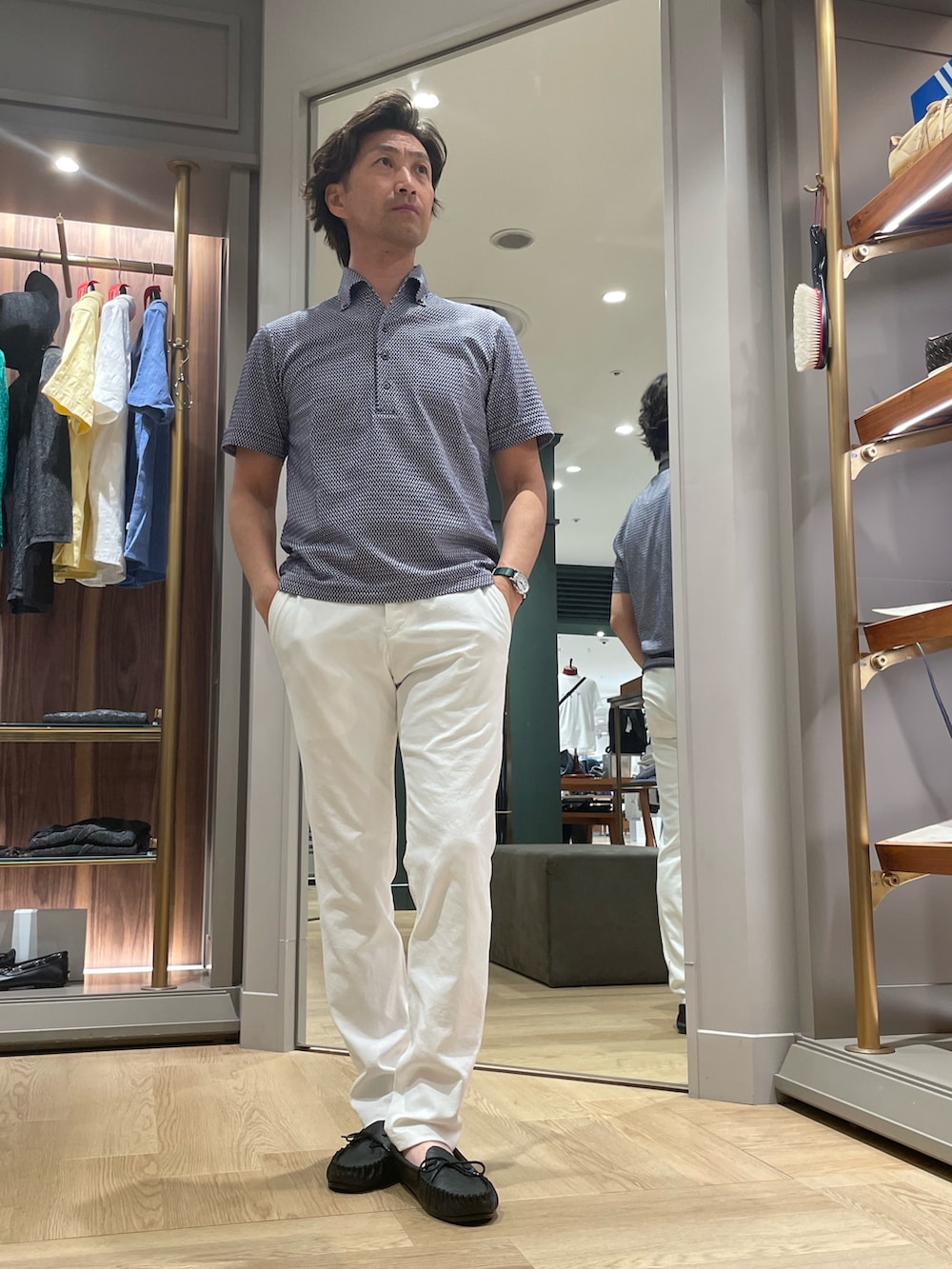ブルー系のポロシャツ、ホワイト系のその他パンツ、ブラック系のモカシン/デッキシューズを着用したメンズの夏コーディネートの4枚目の写真
