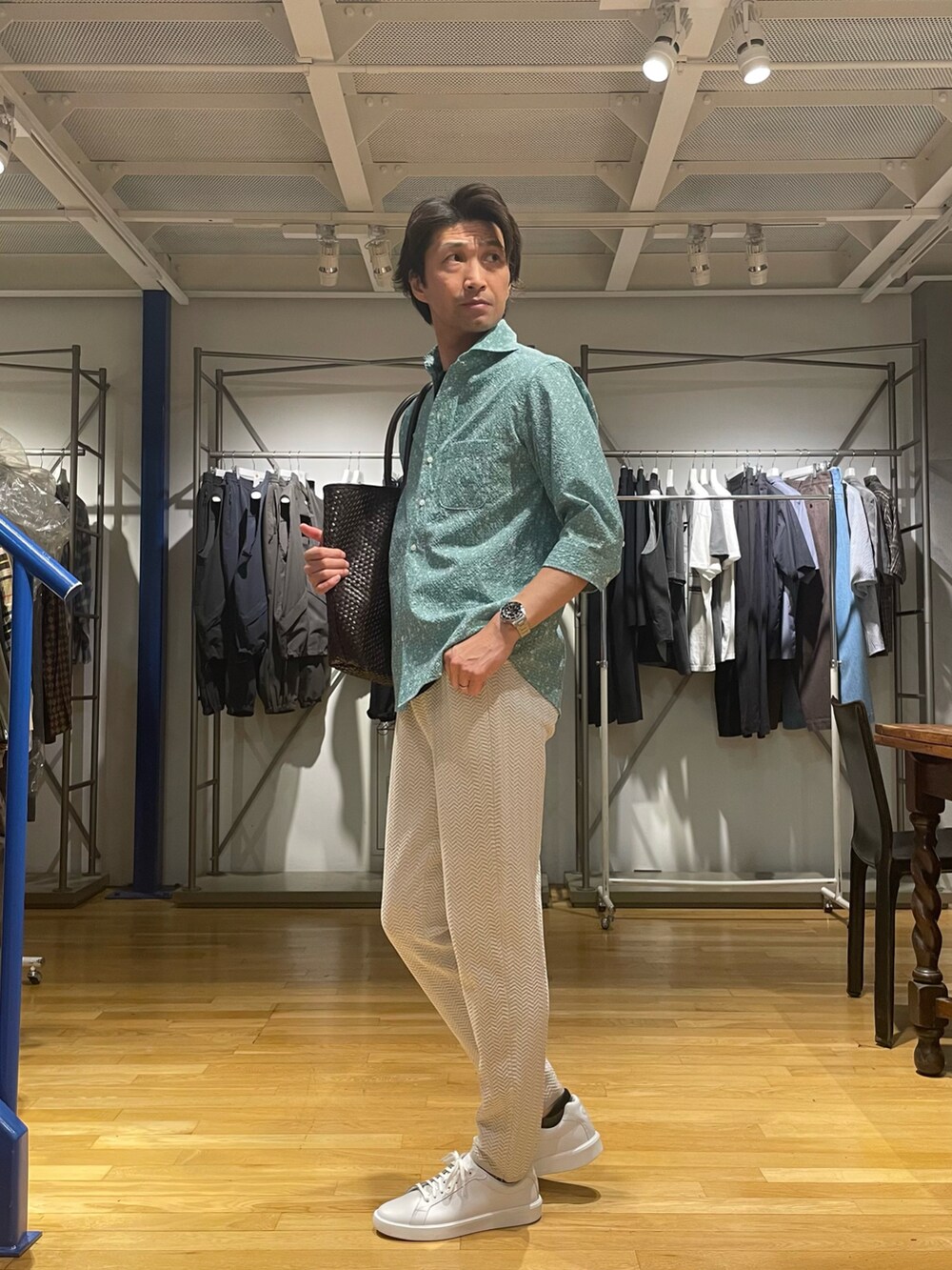 グリーン系のシャツ/ブラウス、ホワイト系のスラックス、ホワイト系のスニーカーを着用したメンズの春コーディネートの2枚目の写真