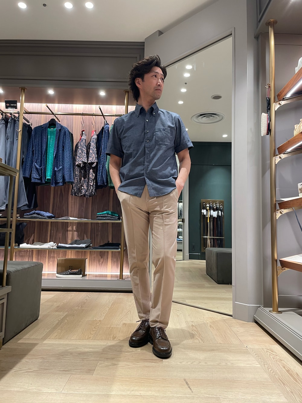 ブルー系のシャツ/ブラウス、ベージュ系のスラックス、ブラウン系のドレスシューズを着用したメンズの夏コーディネートの4枚目の写真