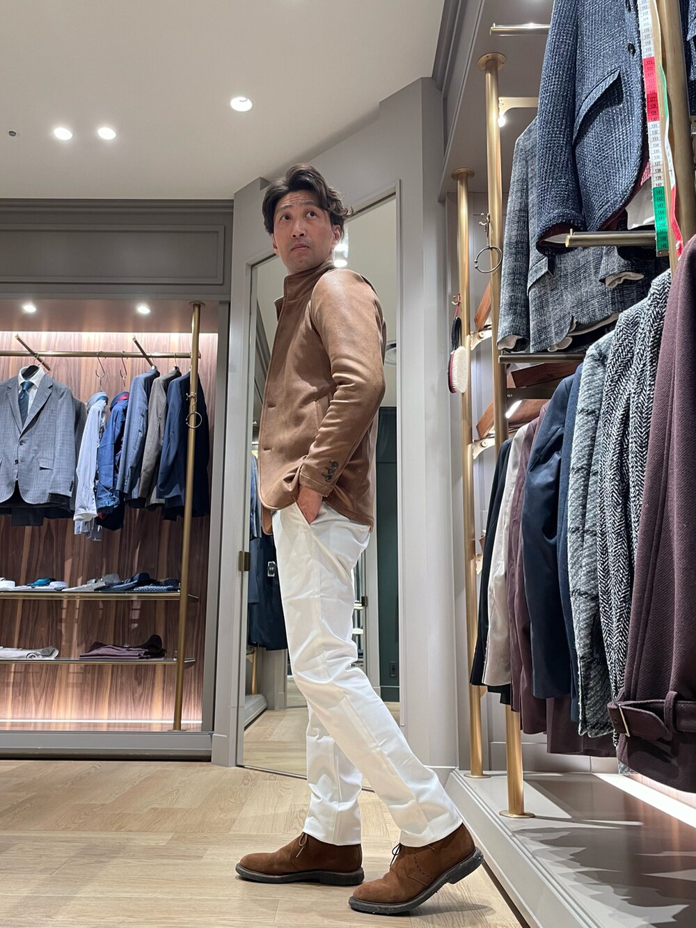 ブラウン系のブルゾン、ホワイト系のスラックス、ブラック系のニット/セーターを着用したメンズの冬コーディネートの2枚目の写真