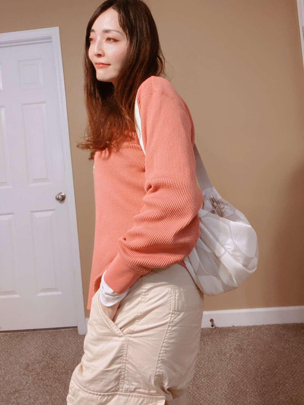 ホワイト系のマウンテンパーカー、グレー系のバッグ、オレンジ系のシャツ/ブラウスを着用したレディースの冬コーディネートの5枚目の写真