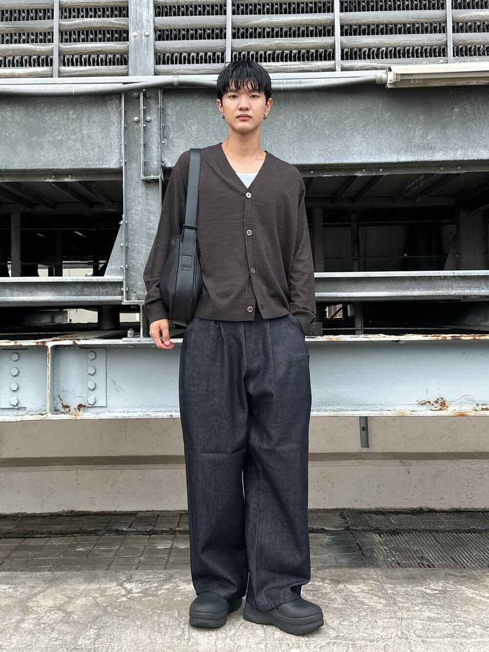 ブルー系のデニムパンツ、ブラック系のショルダーバッグ、ブラウン系のカーディガン/ボレロを着用したメンズの秋コーディネートの2枚目の写真
