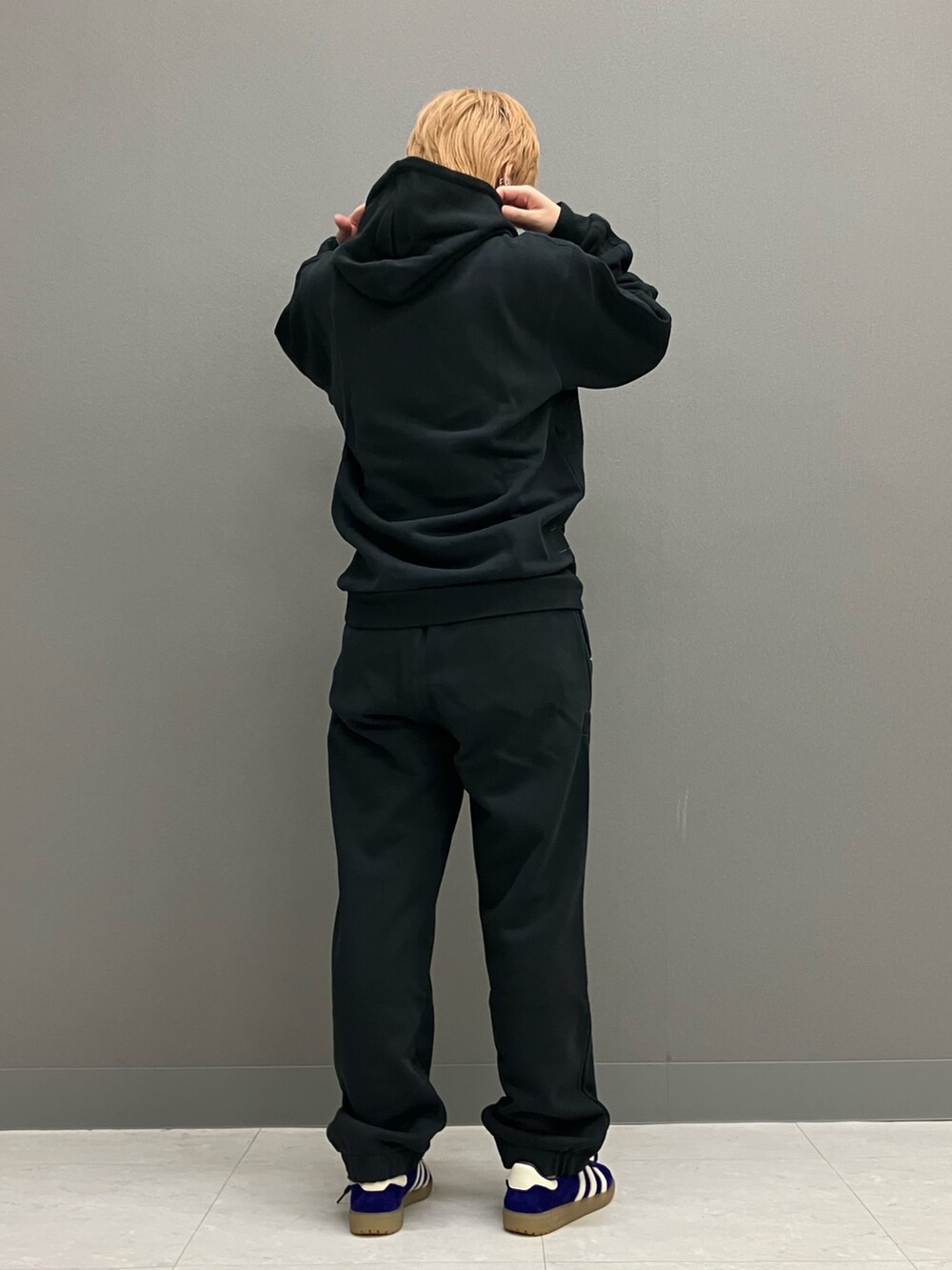 ブラック系のパーカー、ブラック系のその他パンツ、パープル系のスニーカーを着用したレディースの秋コーディネートの4枚目の写真