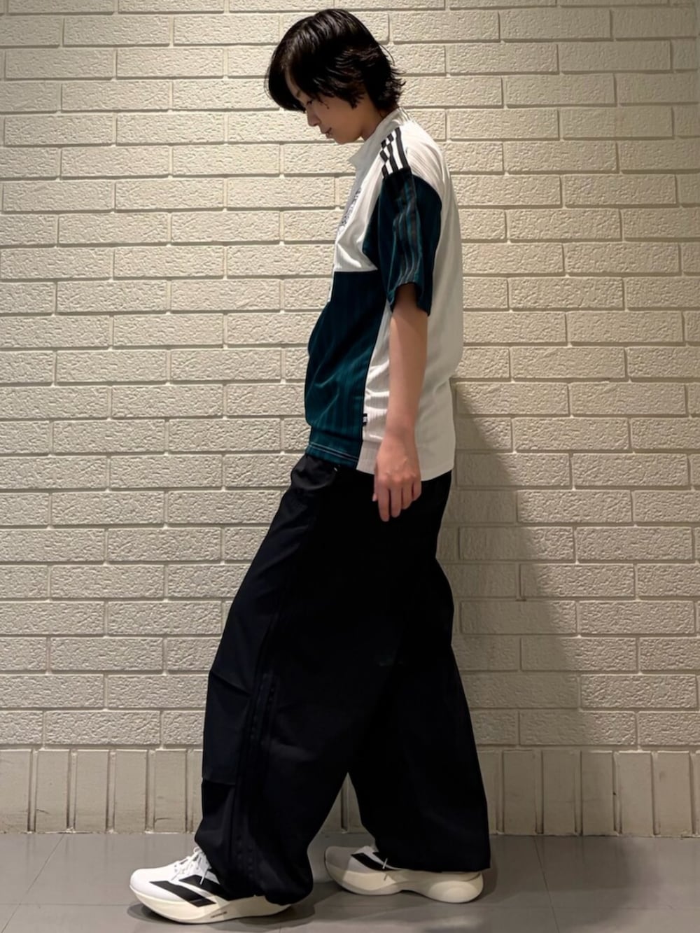 ホワイト系のトップス、ブラック系のその他パンツ、ホワイト系のスニーカーを着用したレディースの春コーディネートの2枚目の写真