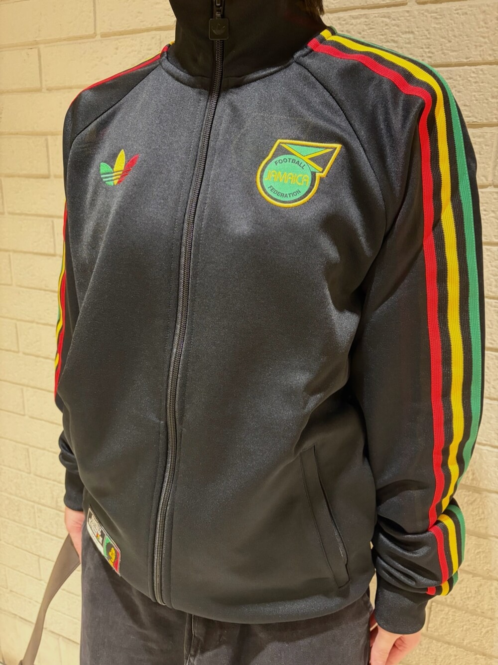 ブラック系のジャージ、ブラウン系のショルダーバッグ、イエロー系のスニーカーを着用したレディースの冬コーディネートの3枚目の写真