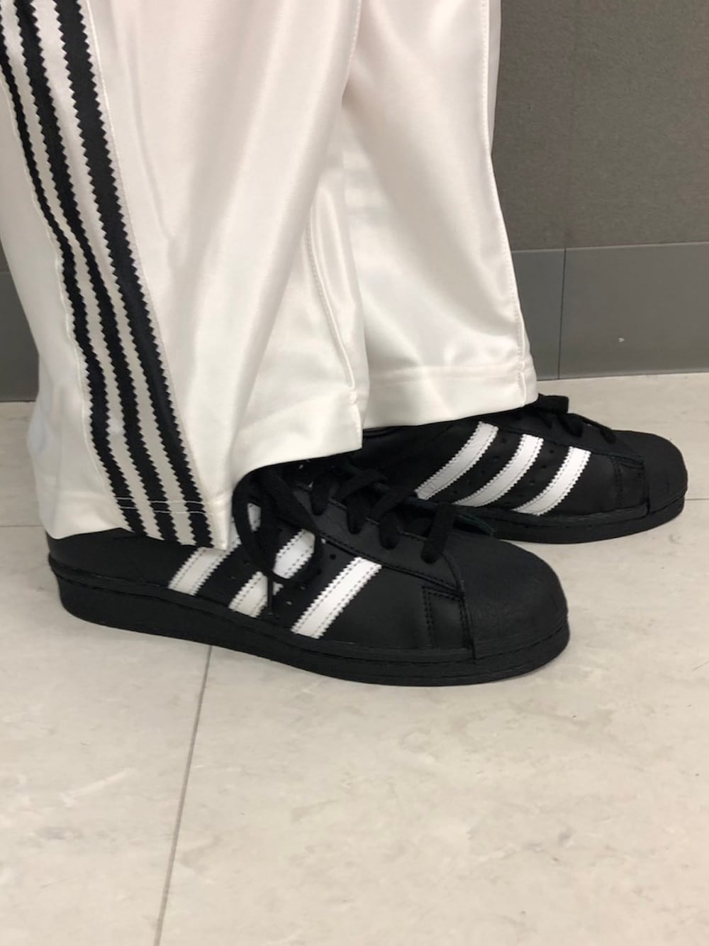 ブラック系のトップス、ホワイト系のジャージ、ホワイト系のその他パンツを着用したレディースの春コーディネートの4枚目の写真