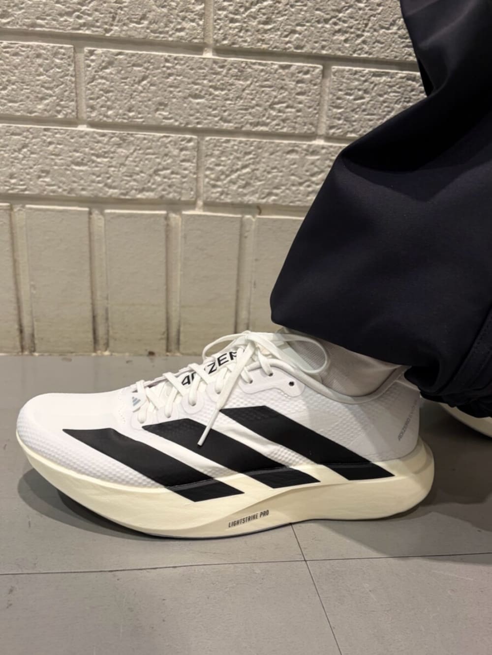 ホワイト系のトップス、ブラック系のその他パンツ、ホワイト系のスニーカーを着用したレディースの春コーディネートの4枚目の写真