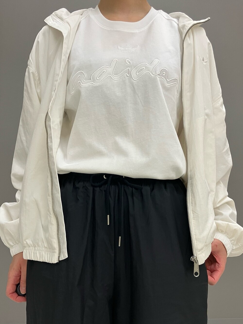 ブラック系のショルダーバッグ、ブラック系のその他パンツ、ホワイト系のTシャツ/カットソーを着用したレディースの冬コーディネートの4枚目の写真