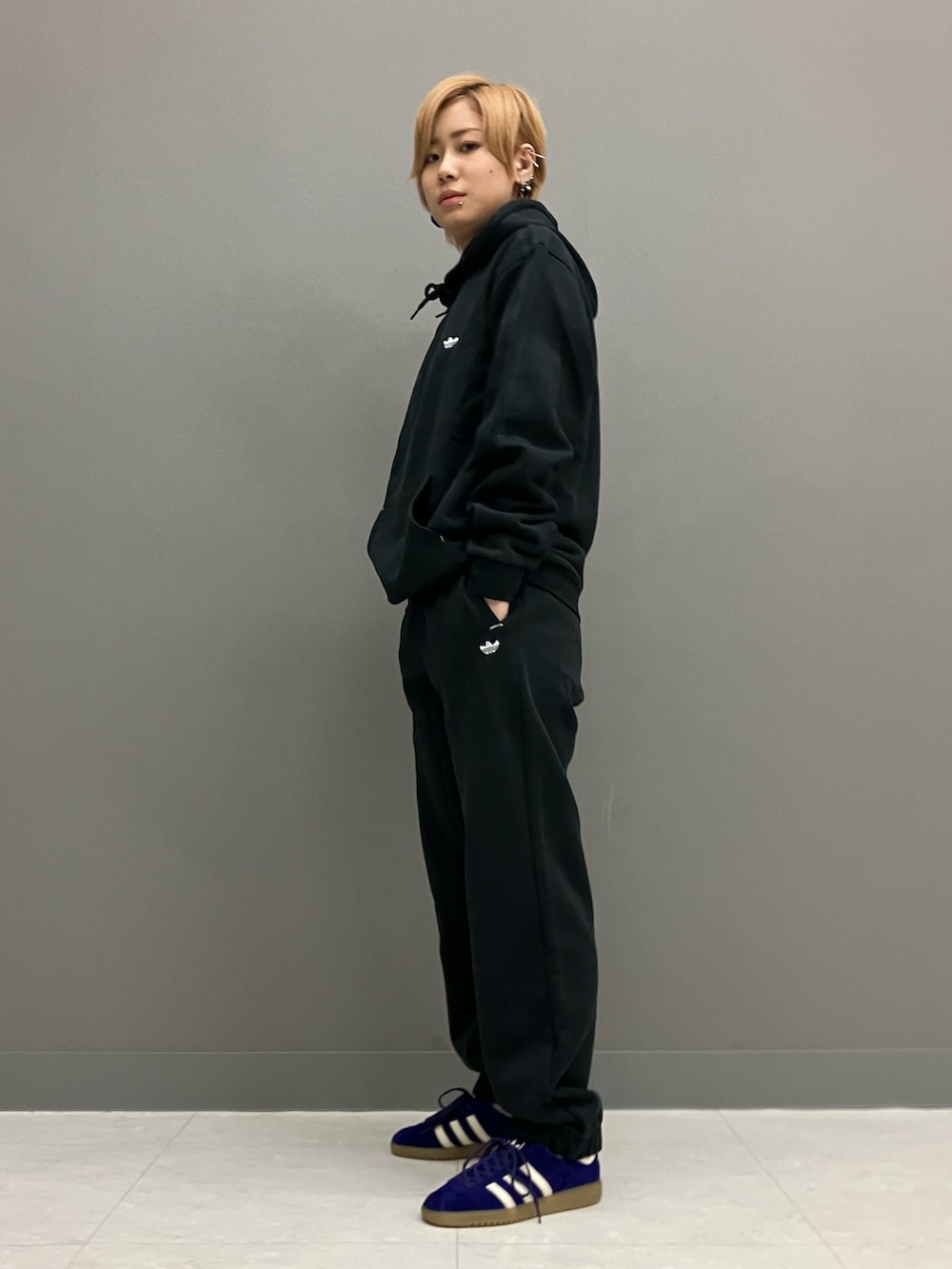 ブラック系のパーカー、ブラック系のその他パンツ、パープル系のスニーカーを着用したレディースの秋コーディネートの3枚目の写真