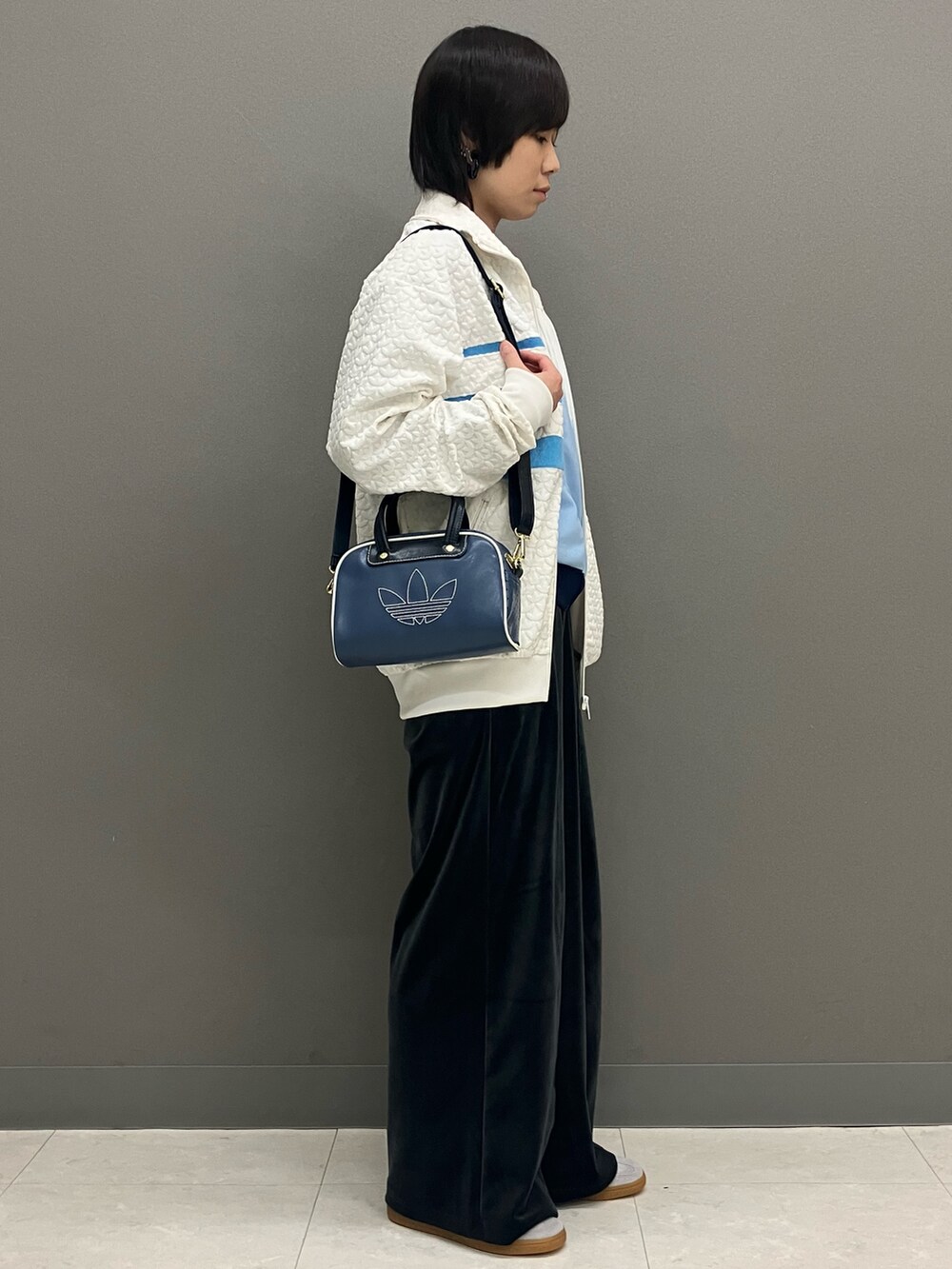 ブルー系のジャージ、ホワイト系のその他アウター、ブルー系のショルダーバッグを着用したレディースの冬コーディネートの2枚目の写真