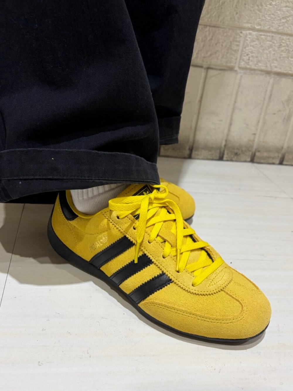 ブラック系のジャージ、ブラウン系のショルダーバッグ、イエロー系のスニーカーを着用したレディースの冬コーディネートの4枚目の写真