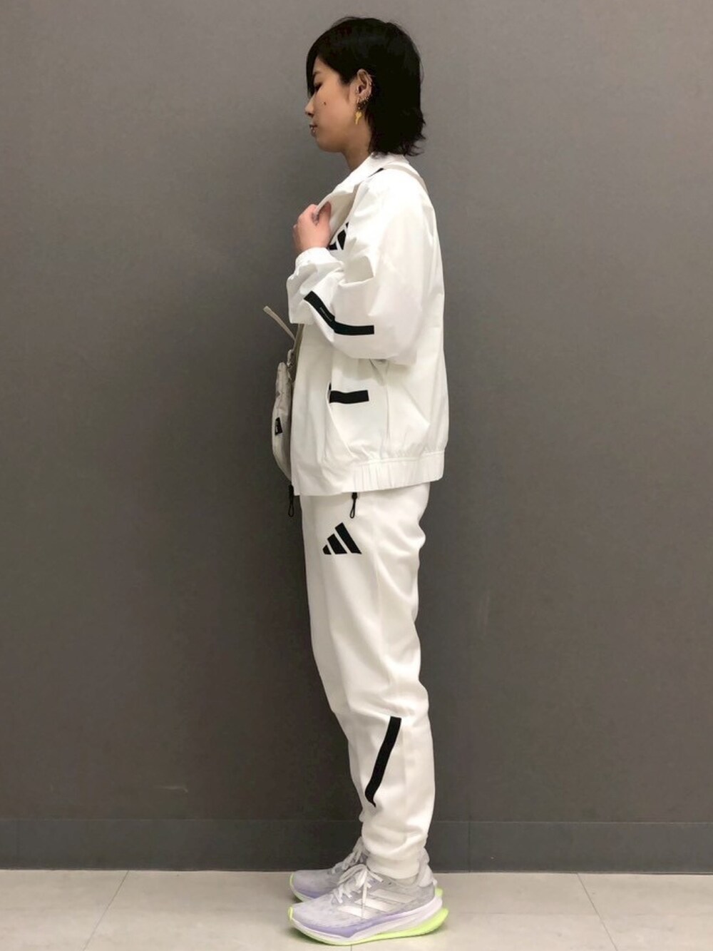 ホワイト系のパーカー、イエロー系のトップス、ホワイト系のその他パンツを着用したレディースの春コーディネートの2枚目の写真