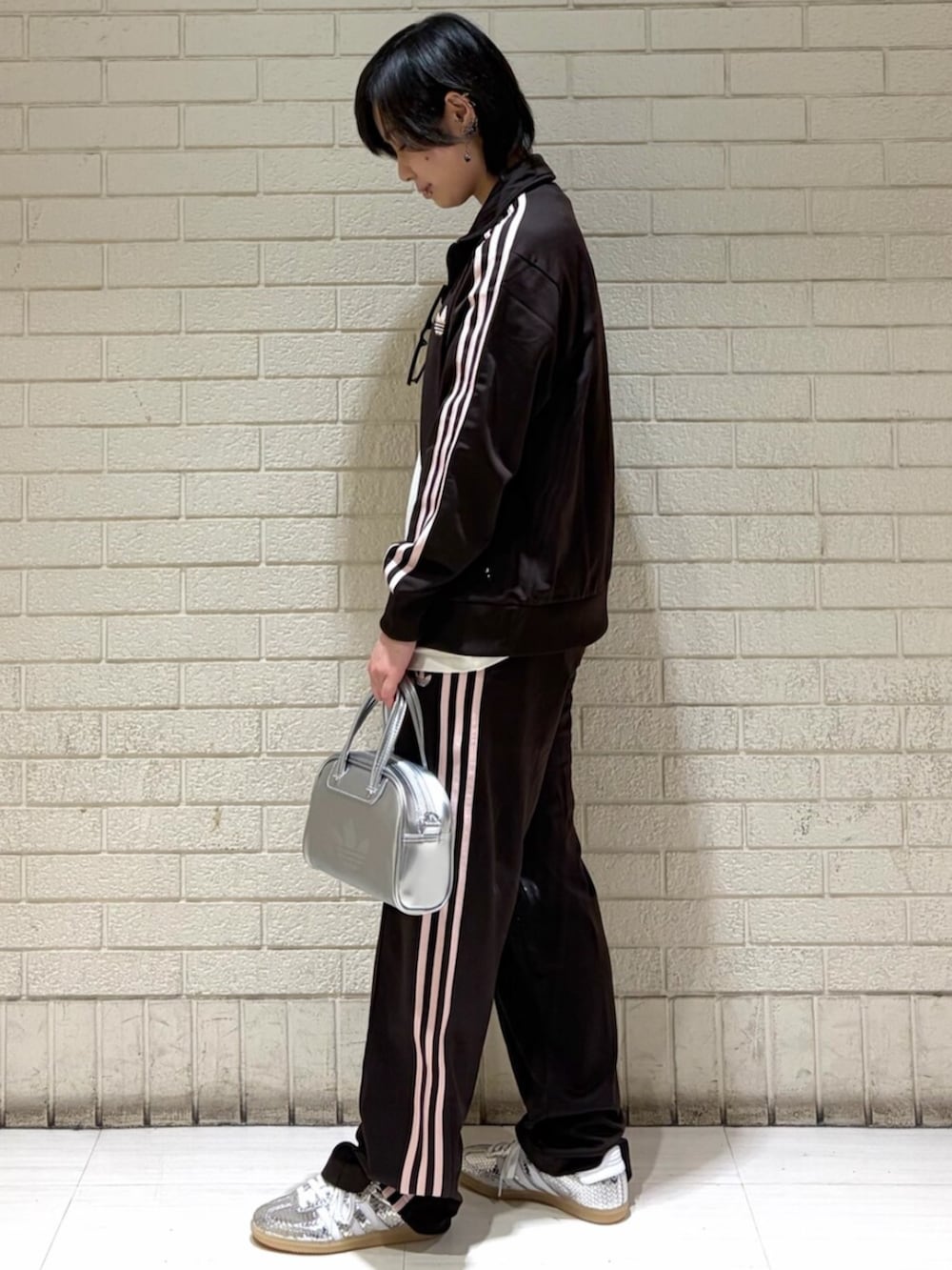 ブラウン系のトップス、ブラウン系のパンツ、シルバー系のショルダーバッグを着用したレディースの春コーディネートの2枚目の写真