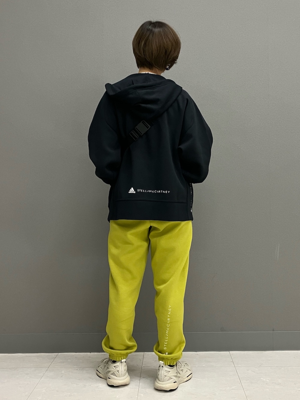 ブラック系のパーカー、ベージュ系のスニーカー、グリーン系のスウェットパンツを着用したレディースの冬コーディネートの3枚目の写真