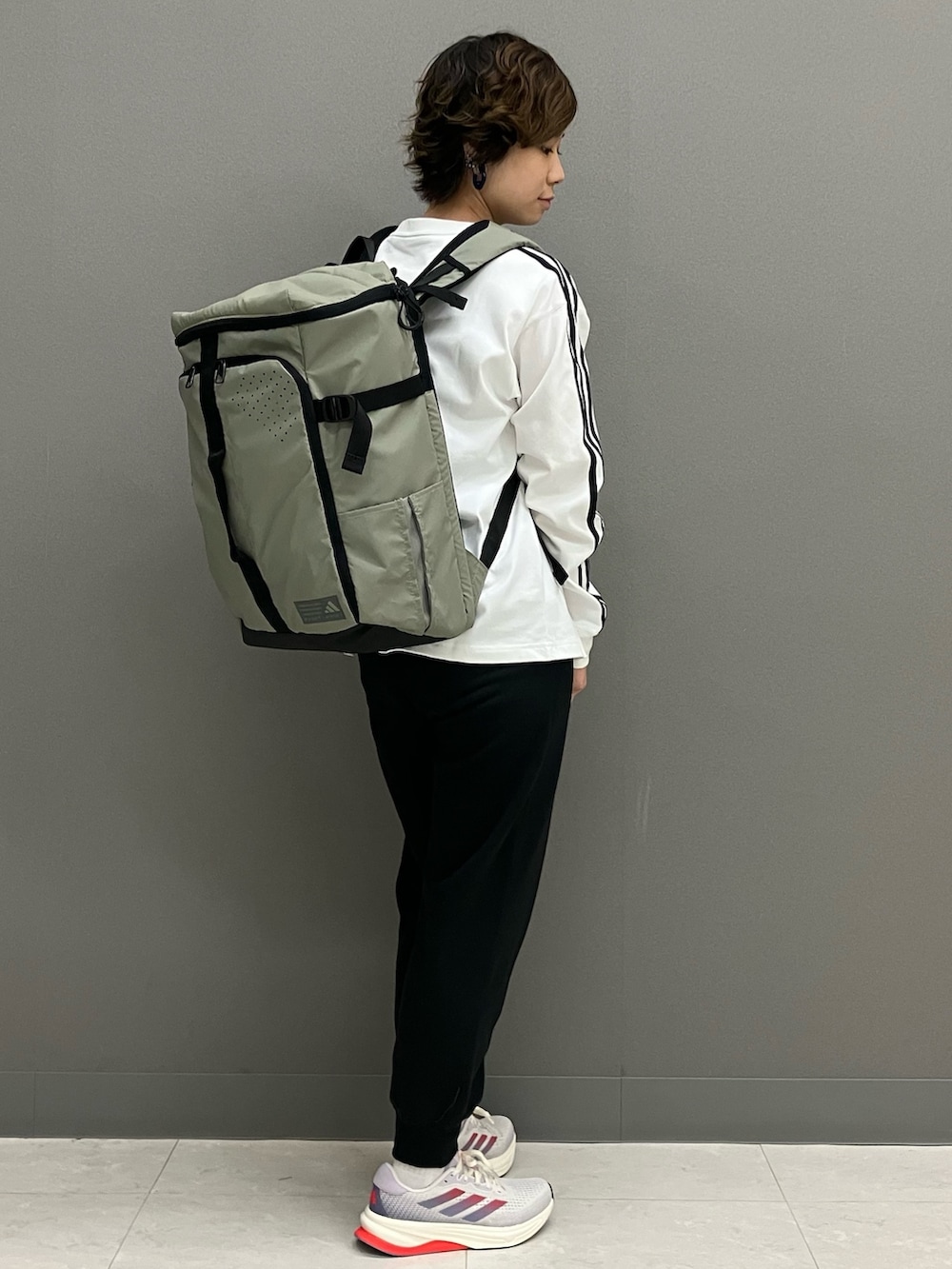 グリーン系のバックパック/リュック、ホワイト系のTシャツ/カットソー、ブラック系のスウェットパンツを着用したレディースの春コーディネートの3枚目の写真