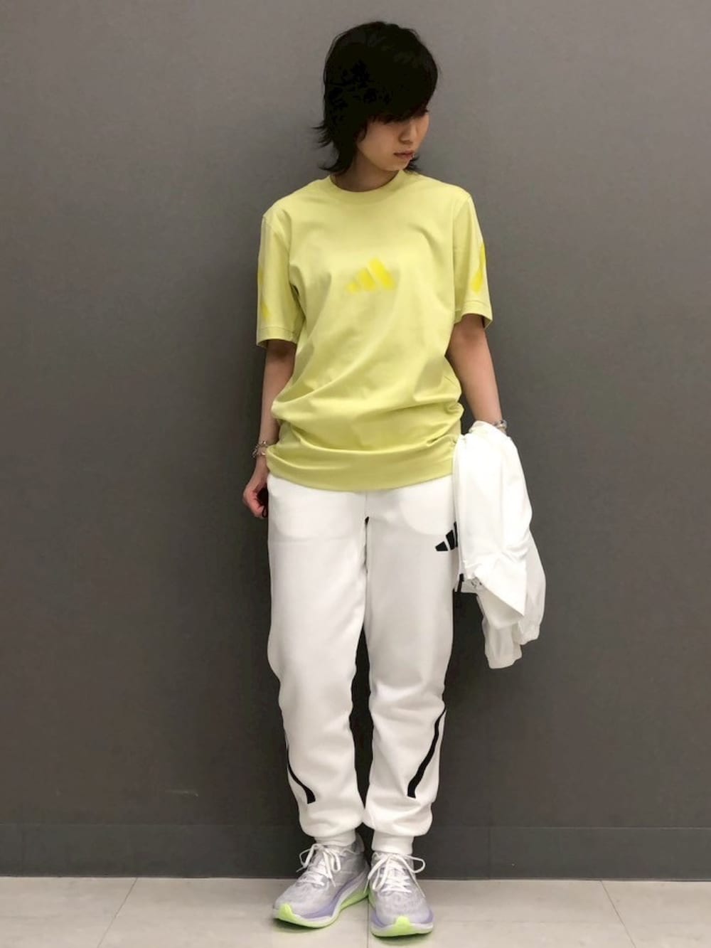 ホワイト系のパーカー、イエロー系のトップス、ホワイト系のその他パンツを着用したレディースの春コーディネートの4枚目の写真