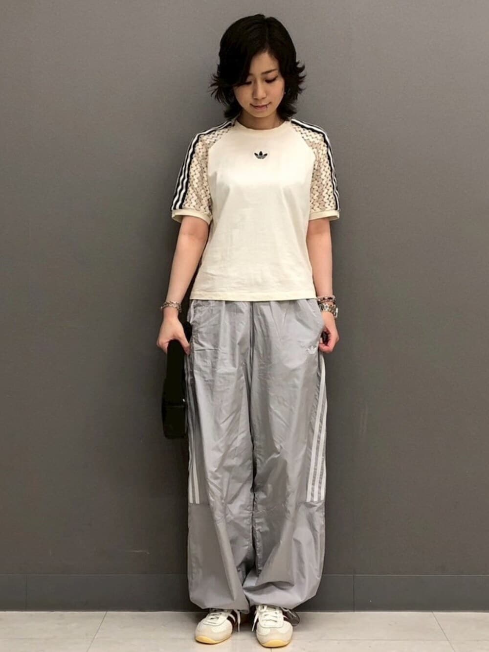 グレー系のナイロンジャケット、グレー系のその他パンツ、ホワイト系のTシャツ/カットソーを着用したレディースの春コーディネートの2枚目の写真