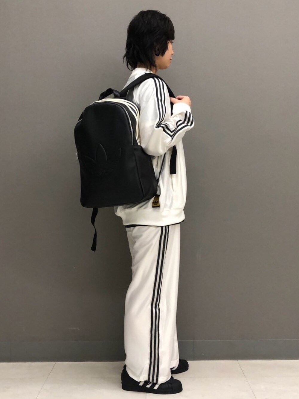 ブラック系のトップス、ホワイト系のジャージ、ホワイト系のその他パンツを着用したレディースの春コーディネートの2枚目の写真