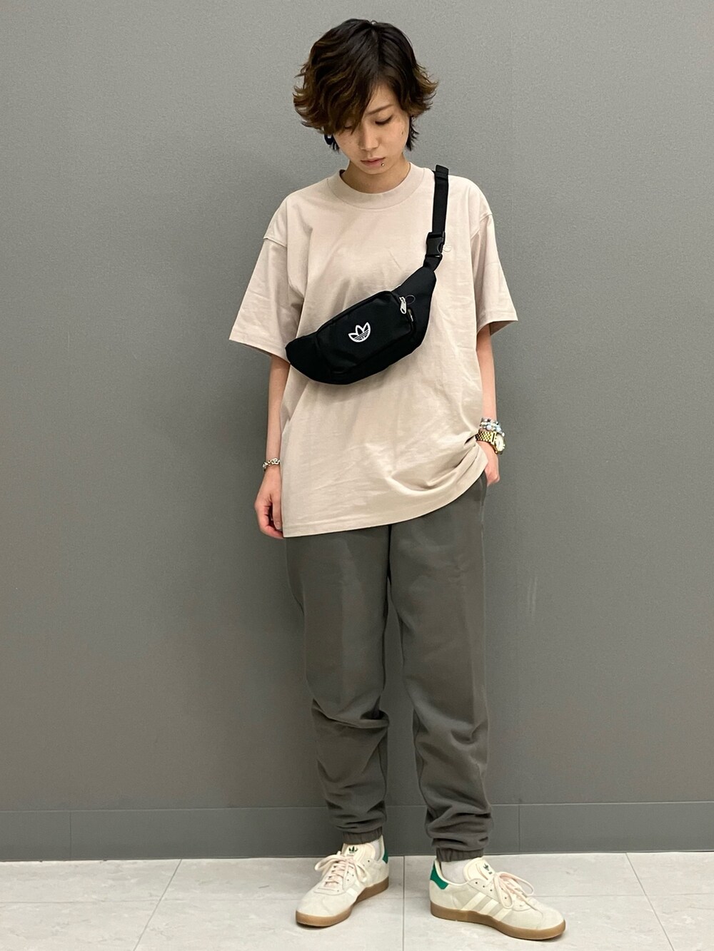 ブラック系のボディバッグ/ウエストポーチ、グレー系のスウェットパンツ、ホワイト系のスニーカーを着用したレディースの春コーディネートの2枚目の写真