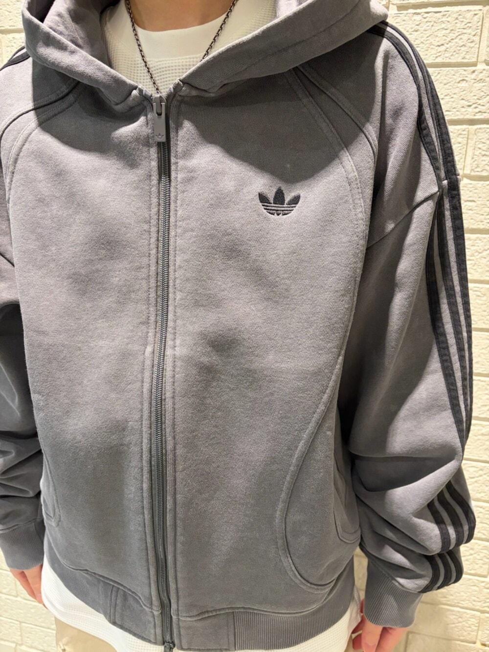 グレー系のパーカー、ホワイト系のTシャツ/カットソー、ベージュ系のその他パンツを着用したレディースの冬コーディネートの3枚目の写真