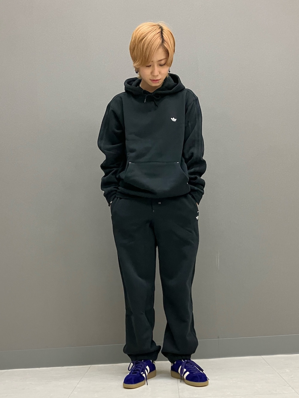 ブラック系のパーカー、ブラック系のその他パンツ、パープル系のスニーカーを着用したレディースの秋コーディネートの2枚目の写真