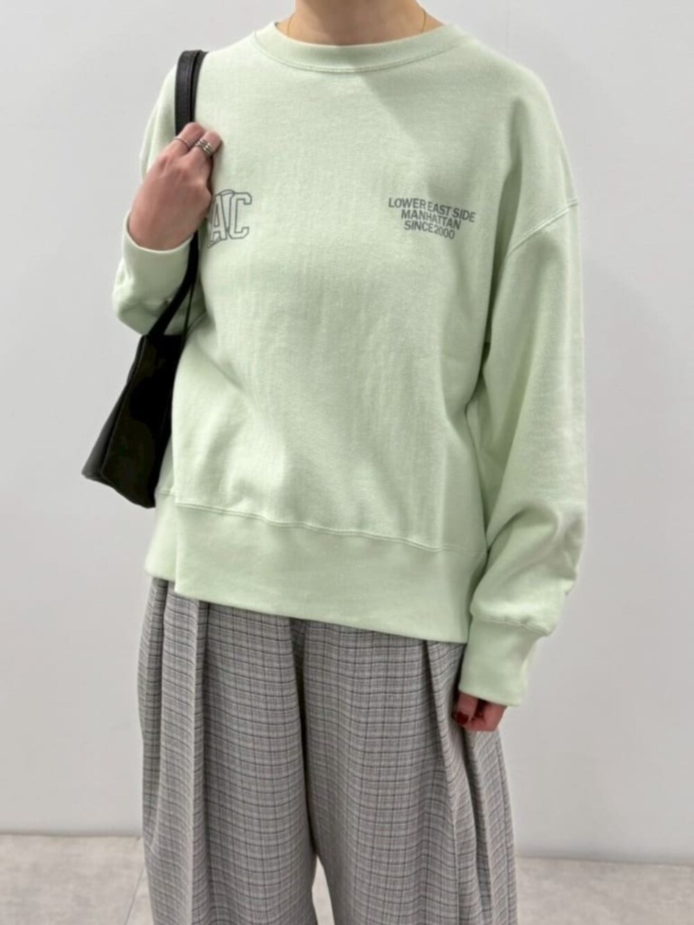 ブラック系のローファー、ブルー系のスウェット、ブラック系のショルダーバッグを着用したレディースの冬コーディネートの6枚目の写真