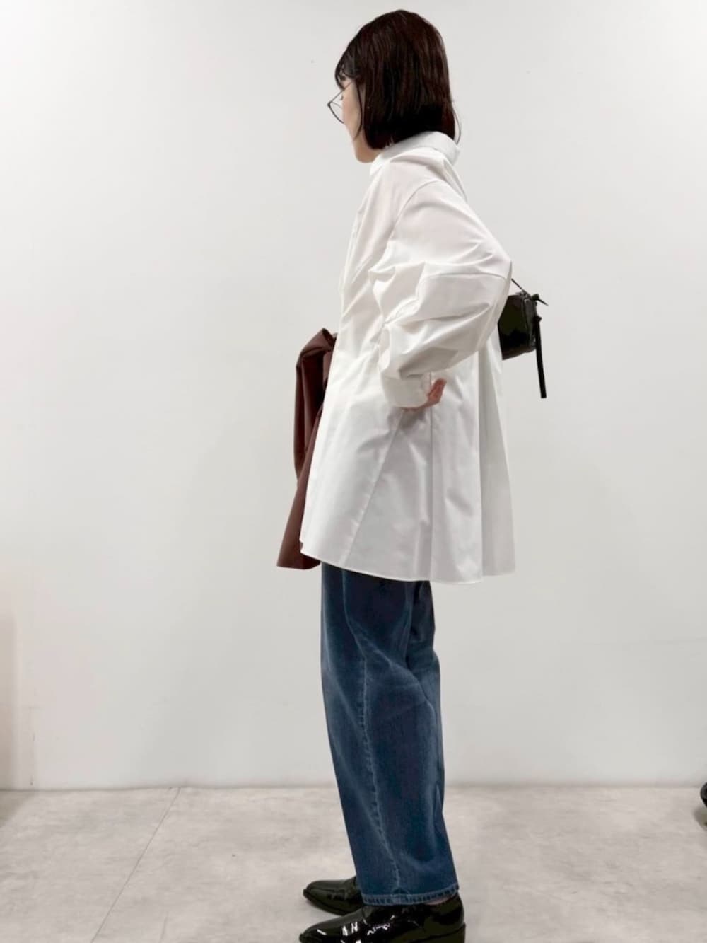 ブラック系のローファー、ホワイト系のシャツ/ブラウス、ブラック系のボストンバッグを着用したレディースの冬コーディネートの4枚目の写真