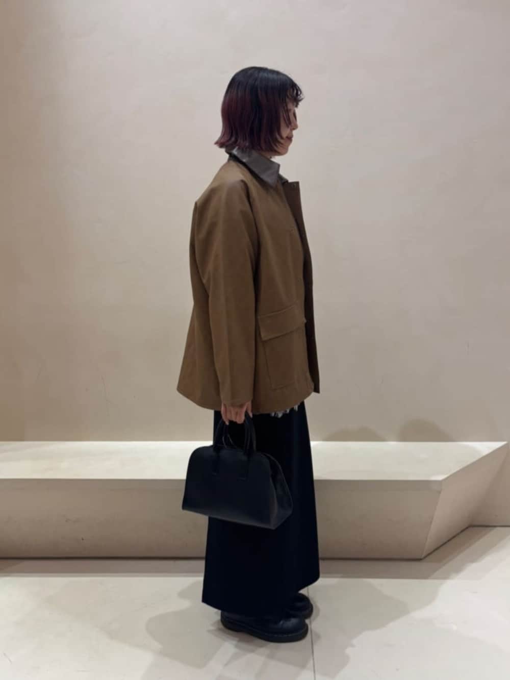 ブラック系のボストンバッグ、ホワイト系のシャツ/ブラウス、ブラック系のスカートを着用したレディースの秋コーディネートの2枚目の写真