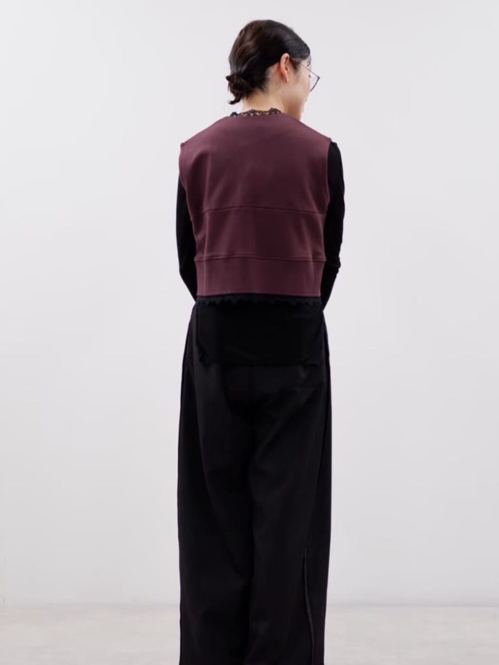 ブラウン系のベスト、ブラック系のスラックスを着用したレディースの秋コーディネートの3枚目の写真