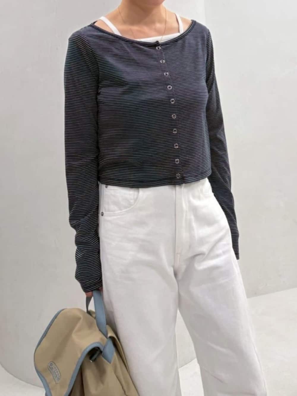 ベージュ系のバックパック/リュック、ホワイト系のデニムパンツ、ブルー系のカーディガン/ボレロを着用したレディースの春コーディネートの9枚目の写真