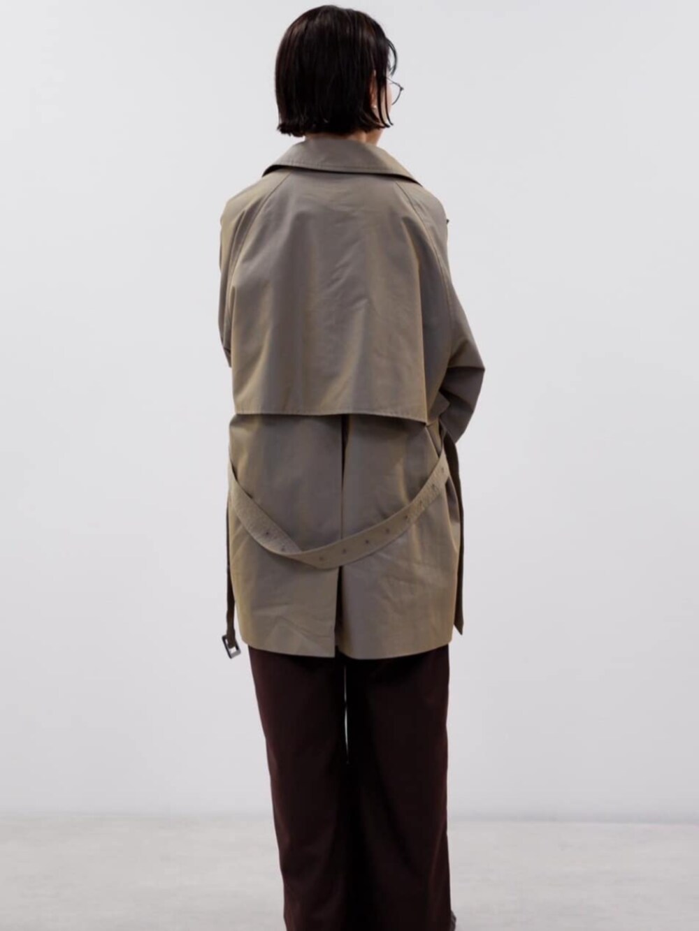 ブラウン系のスラックス、ブルー系のトレンチコート、その他のトートバッグを着用したレディースの秋コーディネートの3枚目の写真