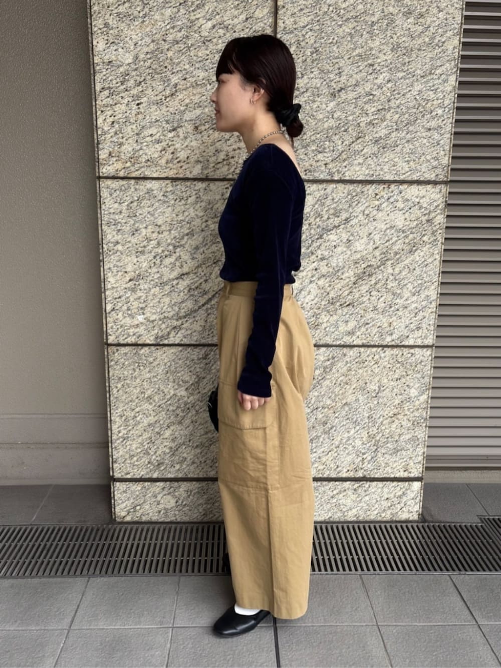 イエロー系のチノパンツを着用したレディースの秋コーディネートの2枚目の写真