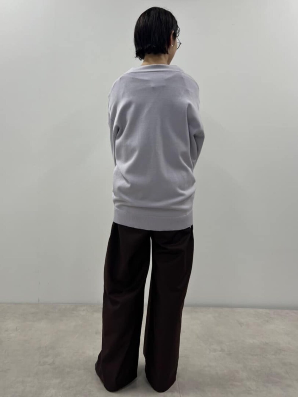 パープル系のカーディガン/ボレロ、ブラウン系のスラックスを着用したレディースの秋コーディネートの3枚目の写真