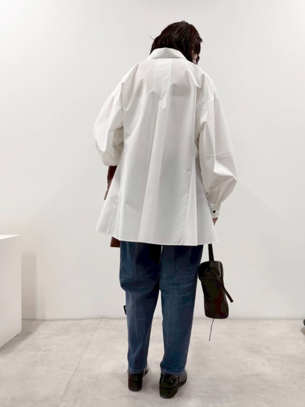 ブラック系のローファー、ホワイト系のシャツ/ブラウス、ブラック系のボストンバッグを着用したレディースの冬コーディネートの5枚目の写真