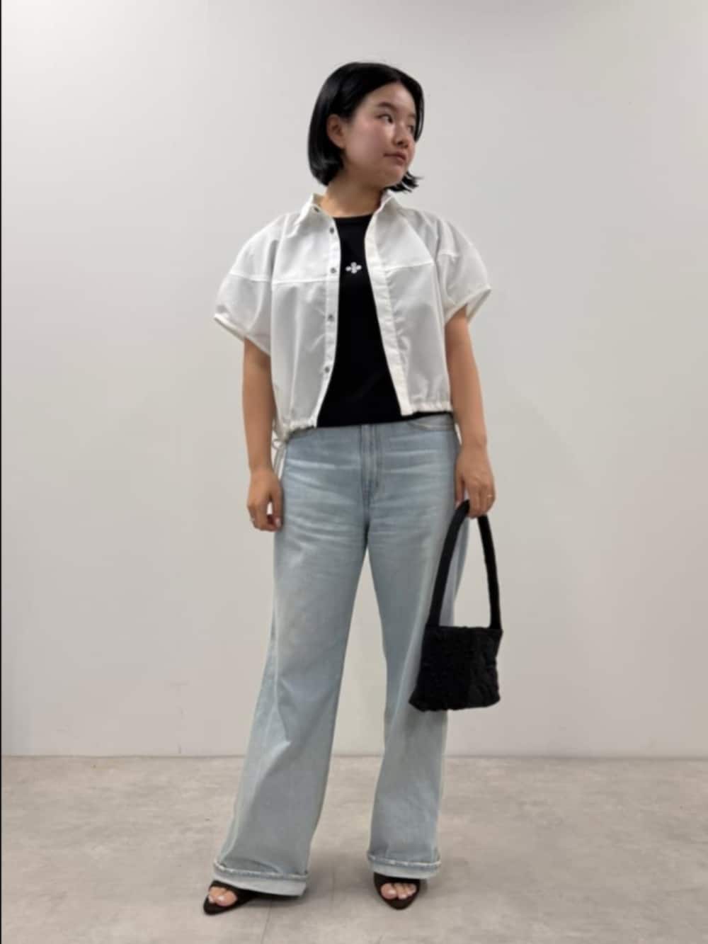 ホワイト系のシャツ/ブラウス、ブラック系のTシャツ/カットソー、ブラック系のハンドバッグを着用したレディースの夏コーディネートの3枚目の写真