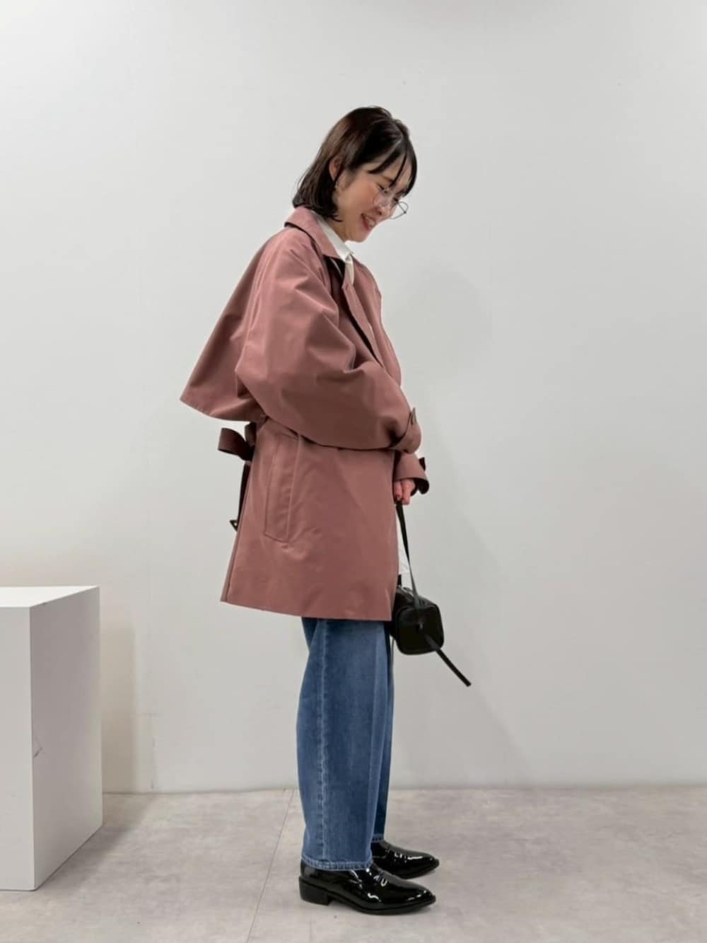 ブラック系のローファー、ホワイト系のシャツ/ブラウス、ブラック系のボストンバッグを着用したレディースの冬コーディネートの2枚目の写真