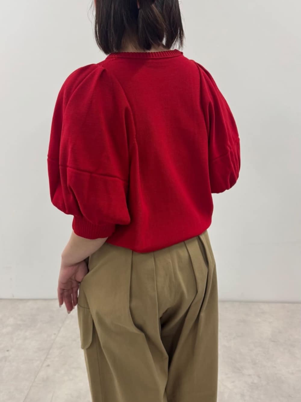 イエロー系のチノパンツ、レッド系のニット/セーター、その他のショルダーバッグを着用したレディースの春コーディネートの3枚目の写真