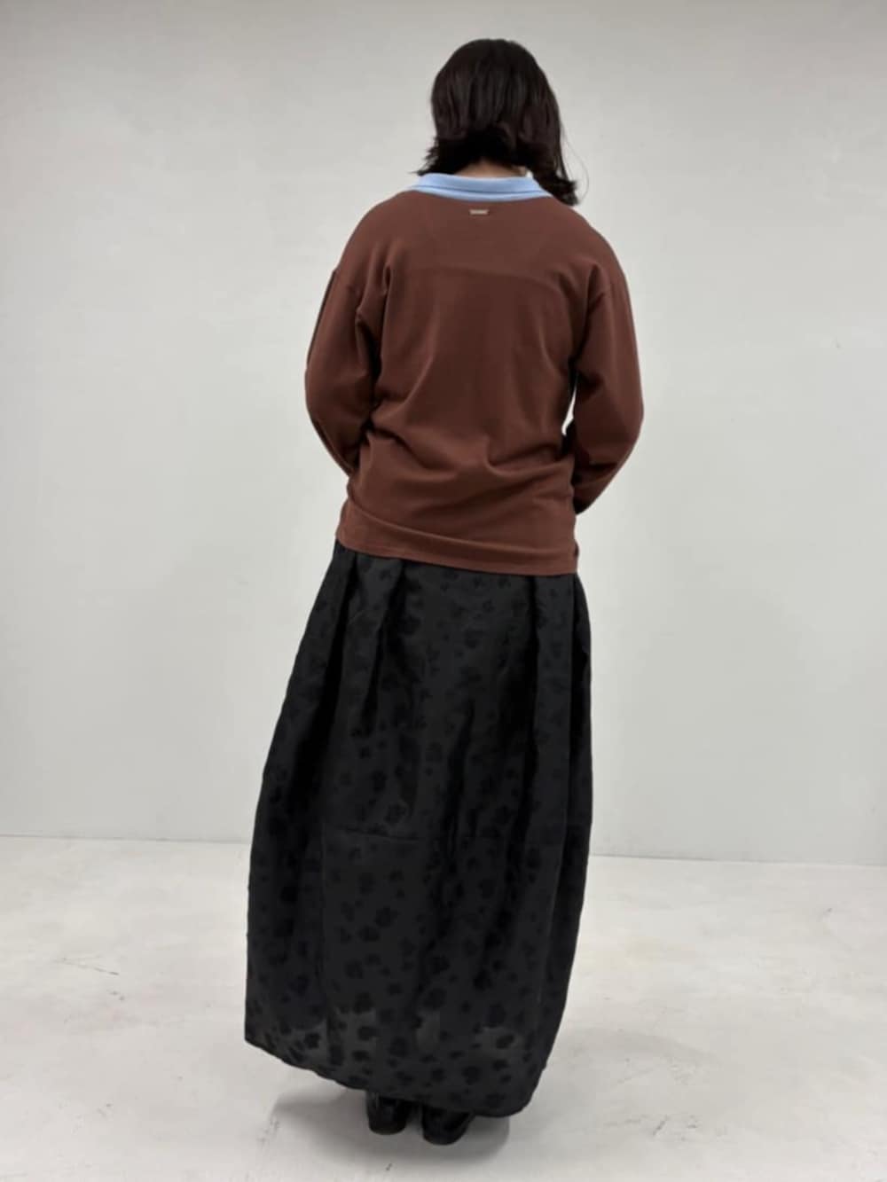 ブラウン系のカーディガン/ボレロ、ブラック系のスカートを着用したレディースの冬コーディネートの3枚目の写真