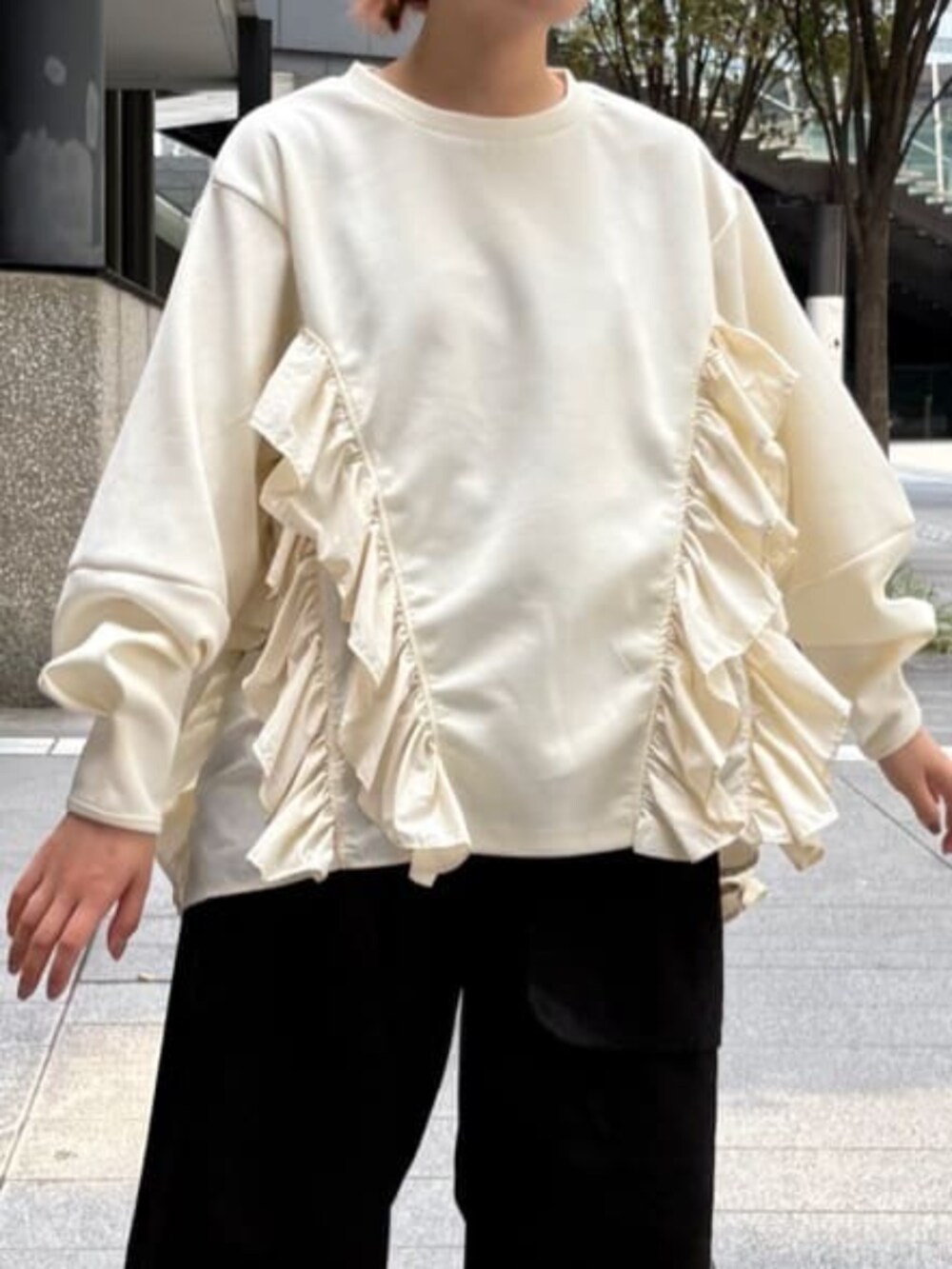 ホワイト系のスウェット、ブラック系のチノパンツを着用したレディースの秋コーディネートの4枚目の写真